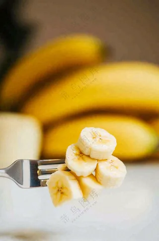 香蕉刀叉插着的香蕉片水果摄影图