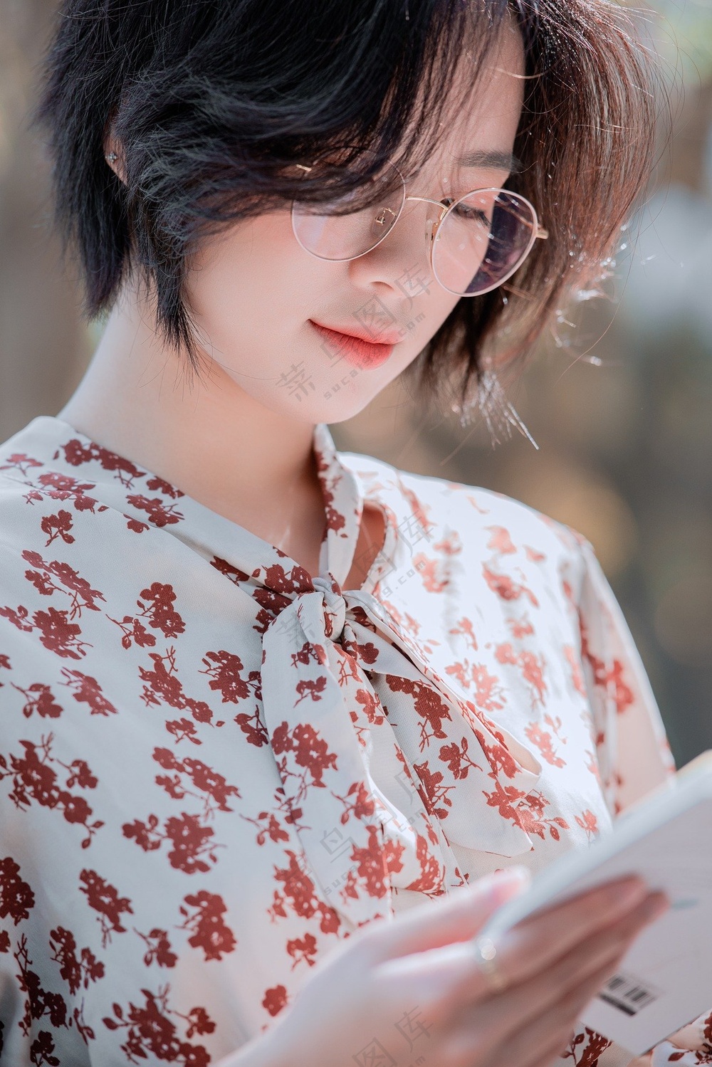 短发美女戴眼镜低头认真看书图片