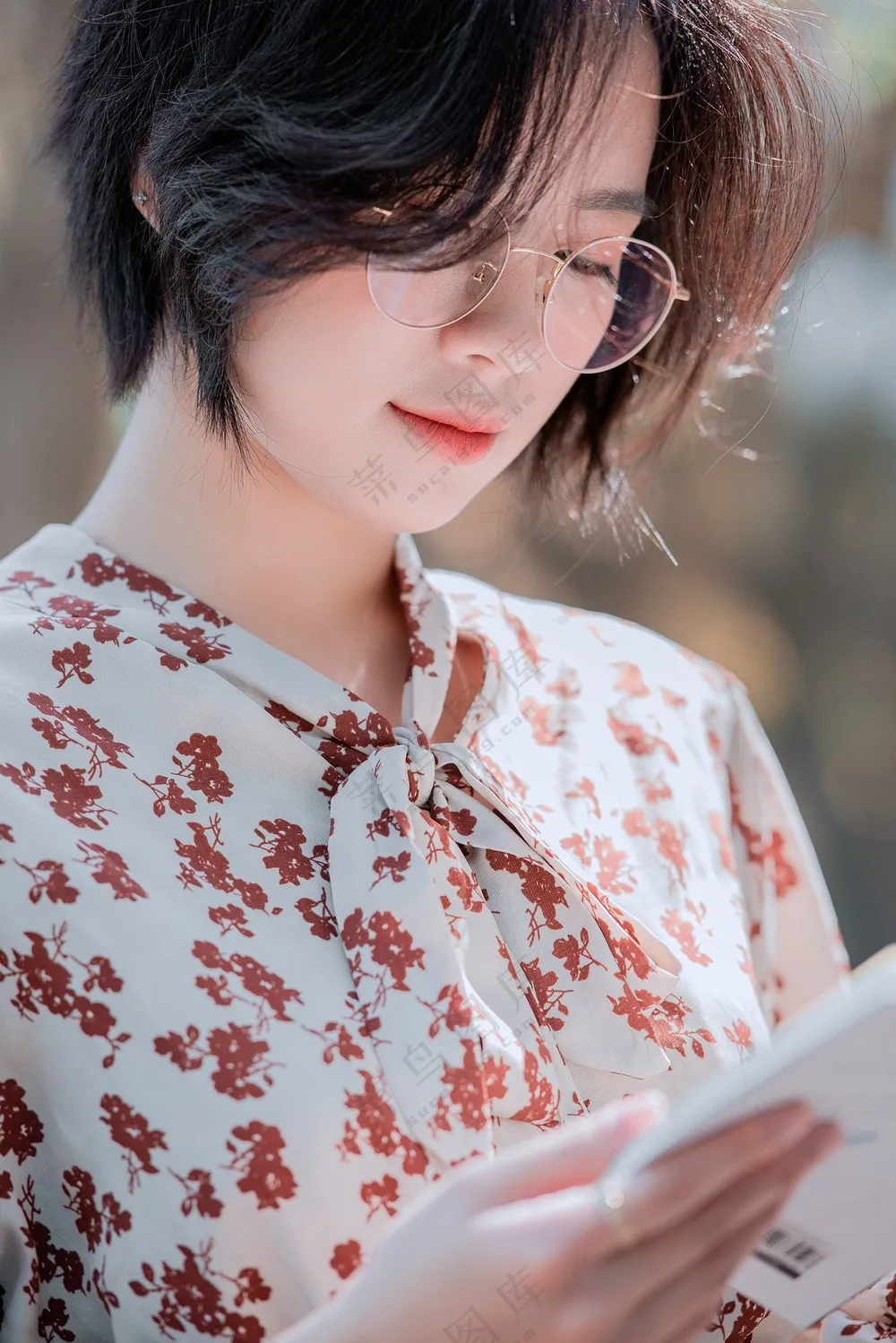 短发美女戴眼镜低头认真看书图片