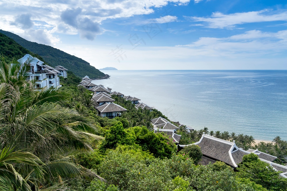 静谧海滨：白棕建筑与翠绿植被的和谐画卷