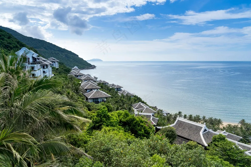 静谧海滨：白棕建筑与翠绿植被的和谐画卷