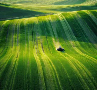 农田庄稼里耕种的机器农忙劳动节摄影图