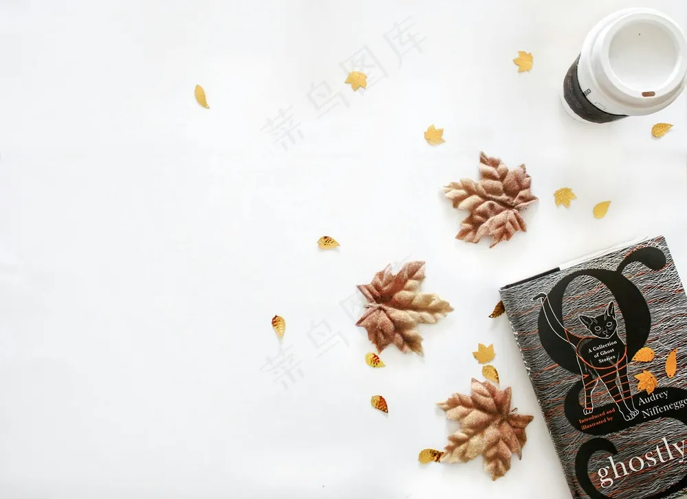 免费 深色魔法书，旁边三片枫叶干 素材图片