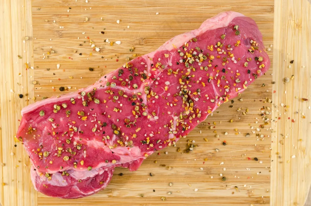 米色的木质表面上的生肉