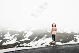 女人独自站在路上面对雪山