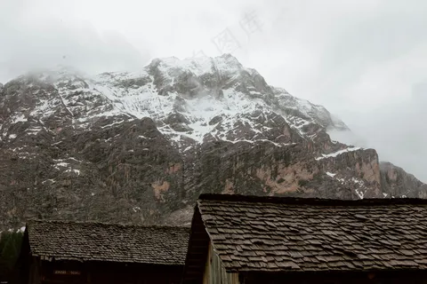 雪覆山巅，屋檐低垂