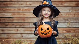 万圣节小女孩抱着南瓜灯装扮节日摄影图