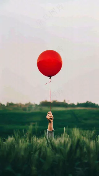 草地天空中的红色气球愚人节摄影图