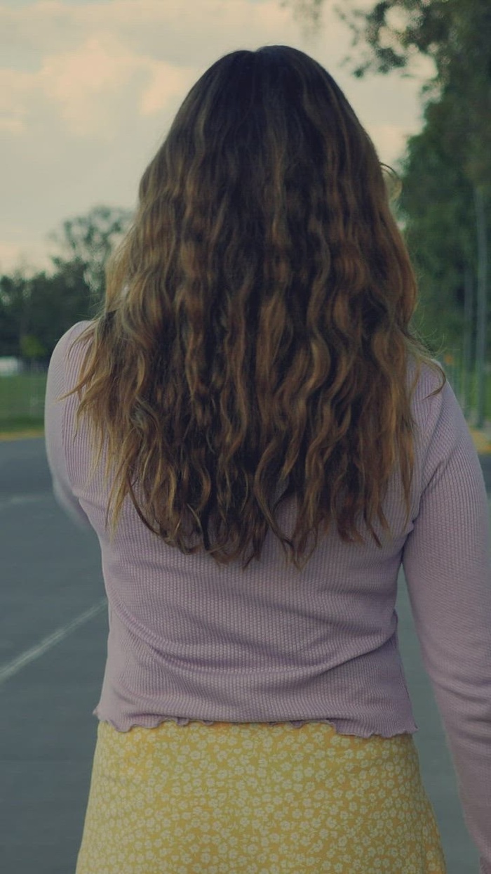 后面的年轻女子在空荡荡的街道上迎面滑冰