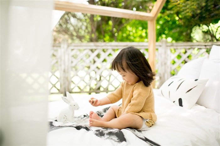 坐在床上玩玩具的可爱幼儿