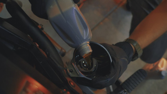 机械工将油倒入发动机