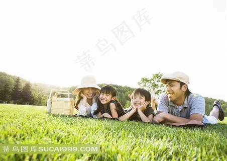 趴在户外草坪上玩乐的父母孩子