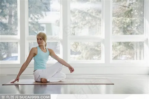 美女盘腿坐瑜伽席上做转身动作