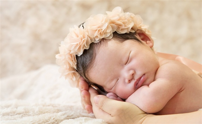 戴着花圈睡着的可爱婴儿