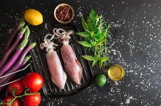 黑色背景下的海鲜鱿鱼和配菜