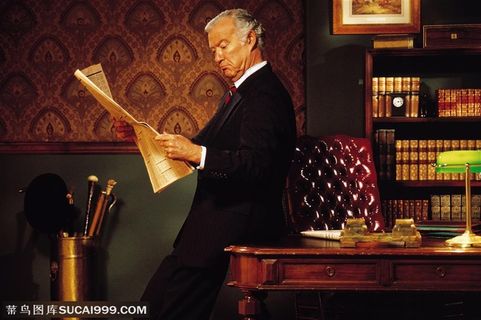 白领男性-靠在桌角看报纸的外国白领男士