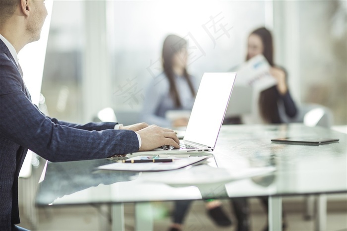 办公室里用电脑工作的商务人士和聊天的美女高清图片