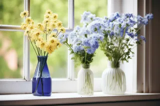 窗台上摆放的花瓶插着花摄影图