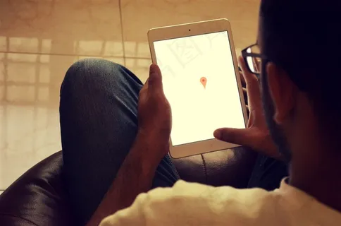 坐在沙发上玩ipad的男人