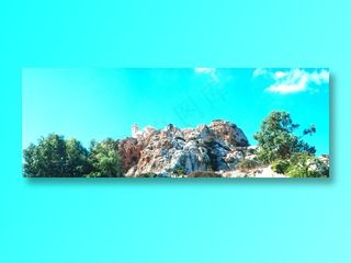 浅蓝色天空下山石树木上的白雪