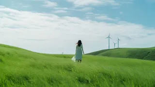 在草原上漫步的女孩摄影图 