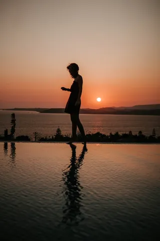 人站在游泳池边的剪影摄影