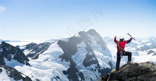 登上雪山山顶的攀登者高清图片
