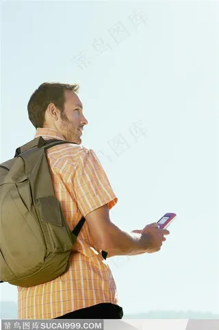 户外探险露营生活-背着背包拿着手机的外国男人