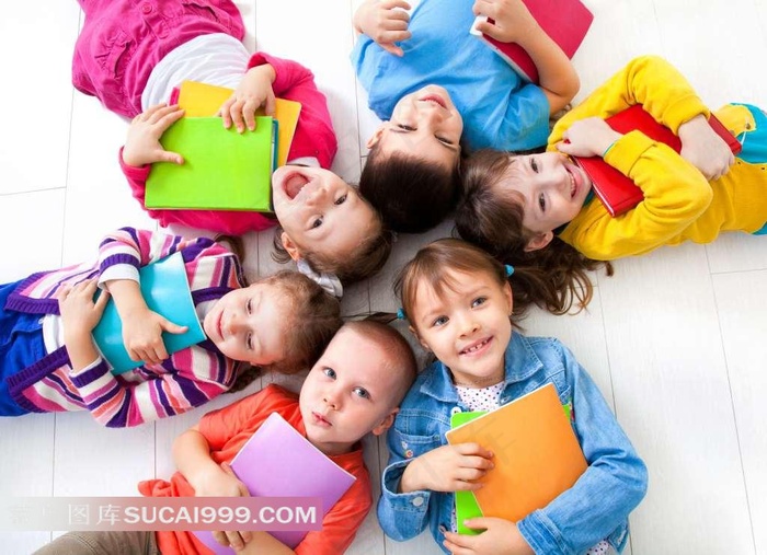 儿童抱着书本一起躺在地上