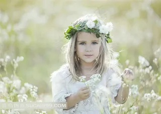 在花丛中穿白裙的美丽小女孩