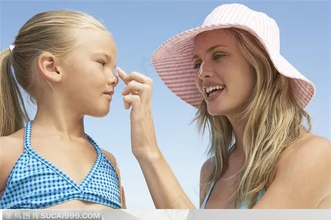 在海边妈妈为女儿涂防晒霜 在海边妈妈为女儿涂防晒霜