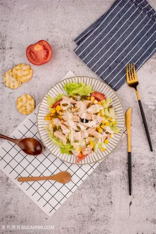 水泥桌上的一盘沙拉与刀叉勺子