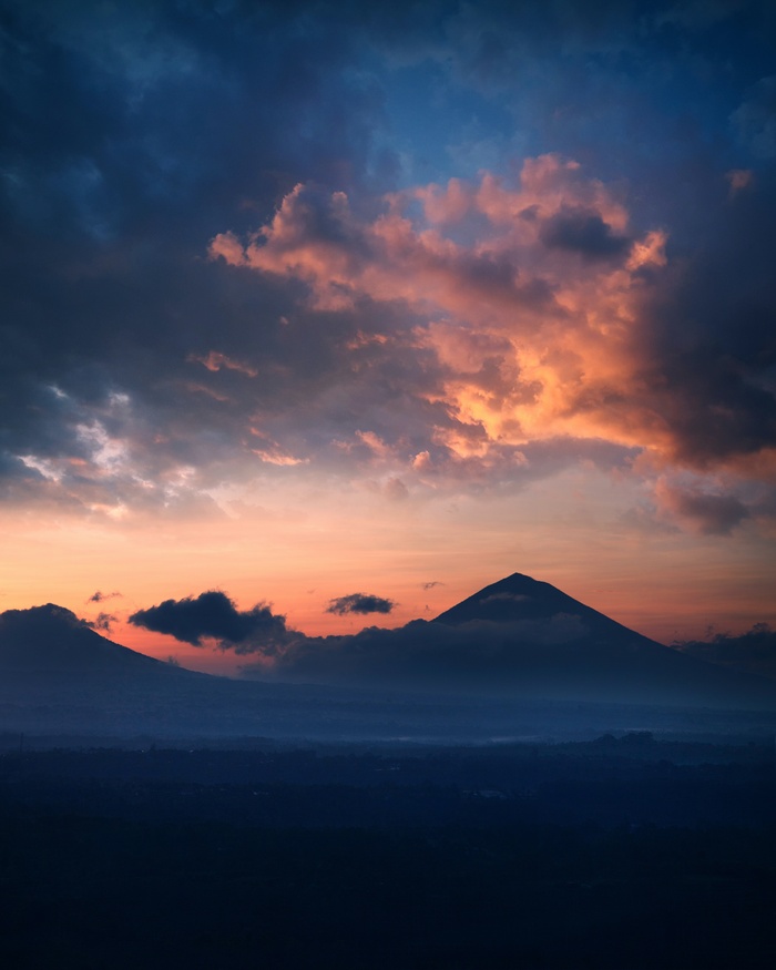 夕阳在多云的天空下山的轮廓