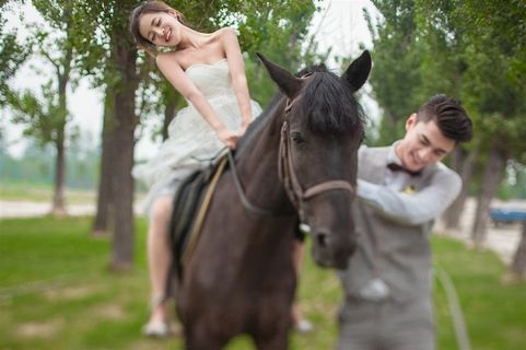 新郞牵着坐在马上的新娘