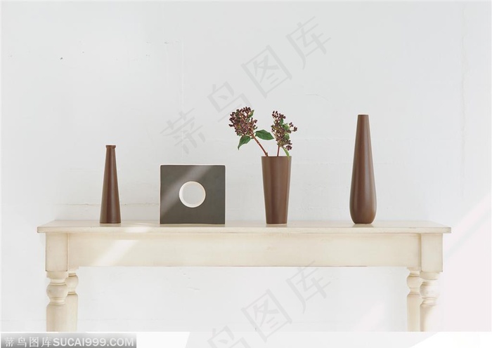 白色矮桌子上的一套咖啡色瓷器和插花