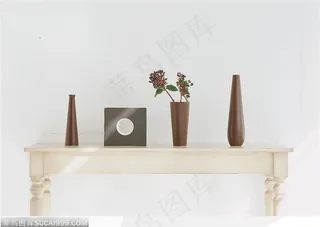 白色矮桌子上的一套咖啡色瓷器和插花