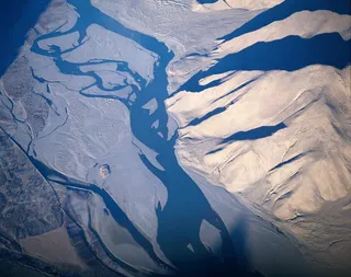 鸟瞰的山岭泥沙间的蓝色河流