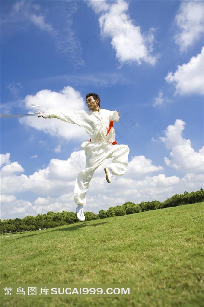 草地上耍太极剑的白衣男人