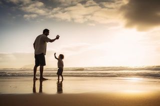 父子海边沙滩玩耍图