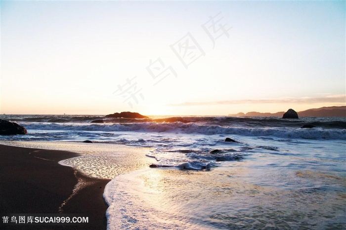夕阳下的海边海滩和海浪摄影图片