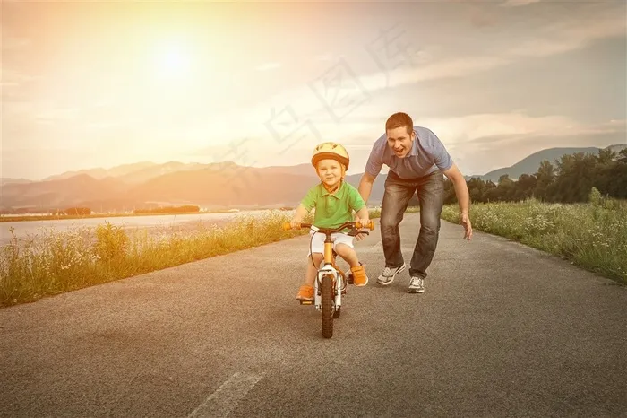 马路上爸爸教孩子骑自行车温馨画面