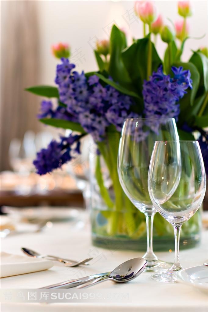 餐桌上的餐具高脚杯和鲜花摄影图片