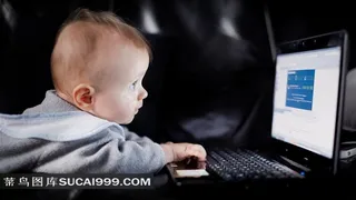 聚精会神玩弄电脑的小婴儿