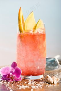 夏日阳光沙滩边的冰镇水果果汁和鲜花贝壳