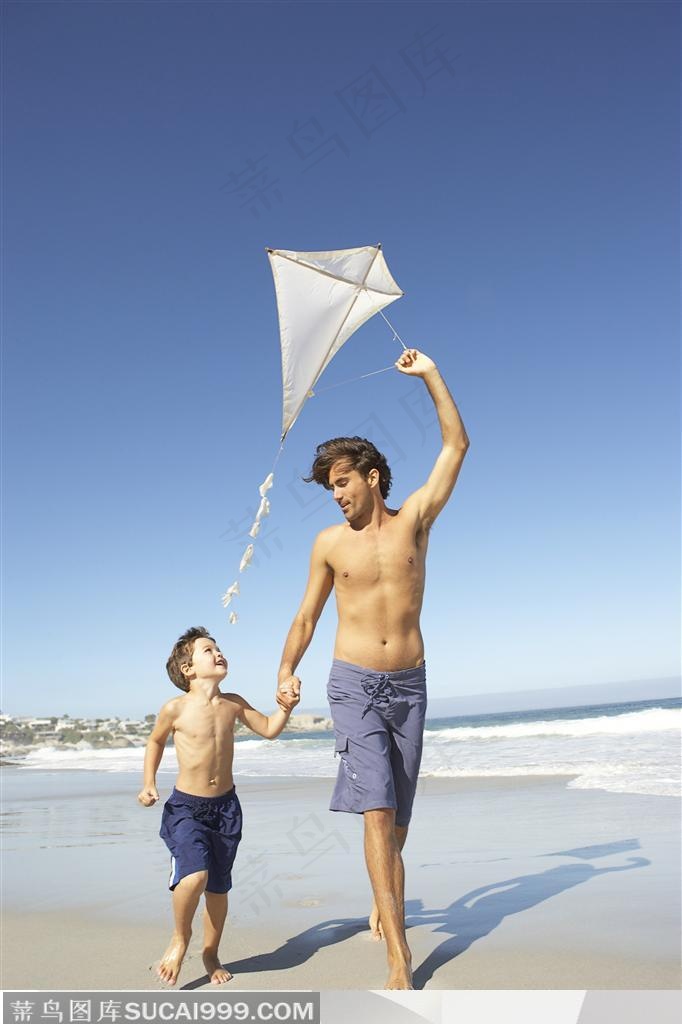在海边手拉手的父子两放风筝