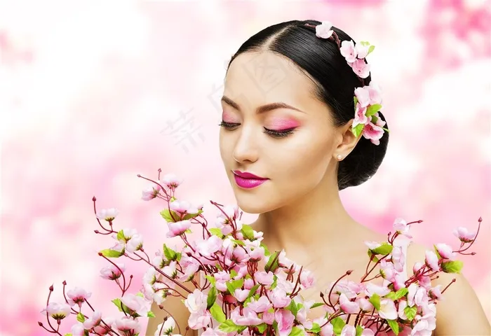 粉红色背景下的头上戴花的女性