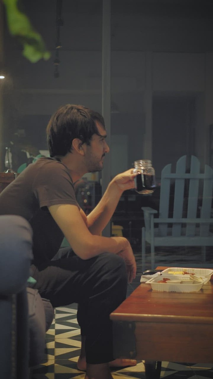 男孩一边看电视一边在沙发上吃饭