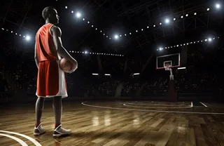 站在黑暗的篮球赛场上的篮球队员高清图片