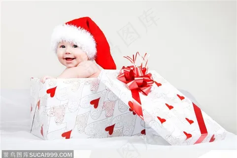 被装在红桃心礼品盒里带着圣诞老人帽子的外国婴儿