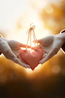 两个手拿着一个小爱心挂件香囊摄影图